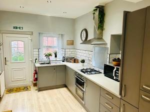 a kitchen with a sink and a stove top oven at The Oaks Cottage in Penrith