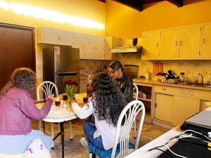 Yanahuara的住宿－T'ikary Wasi Hostel，三人坐在厨房的桌子上