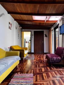 Yanahuara的住宿－T'ikary Wasi Hostel，客厅配有沙发和椅子,铺有木地板