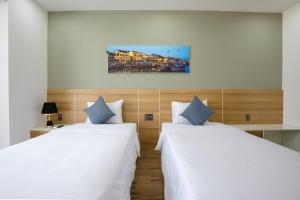 Ліжко або ліжка в номері FIRST Studio Hotel Da Nang