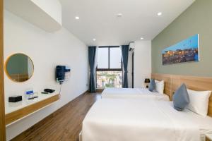 Ліжко або ліжка в номері FIRST Studio Hotel Da Nang