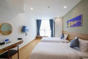 Ліжко або ліжка в номері FIRST Studio Hotel Da Nang