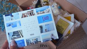 a person holding up a calendar in a box at Tins Hotel City - Athens in Athens