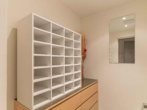 een grote witte boekenplank in een kamer met een spiegel bij B & B Longhin in Maloja