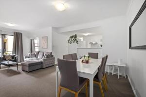 a living room with a white table and chairs at Family Apartment close to Perth City in Perth
