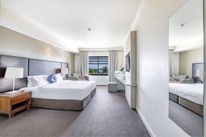una grande camera d'albergo con due letti e una scrivania di An Exceptional Seaside Esplanade Locale with Pool a Darwin