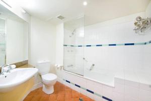 a bathroom with a toilet and a sink and a shower at An Exceptional Seaside Esplanade Locale with Pool in Darwin