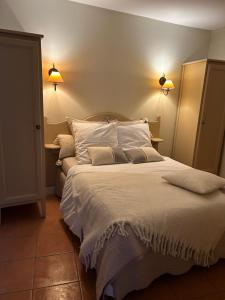 een slaapkamer met een groot bed met witte lakens en kussens bij Appartement vue mer Golfe de Saint-Tropez in Les Issambres
