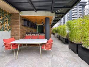 un patio con una mesa blanca y sillas rojas en Apartamento 1 Habitación, Edificio EON, Zona 10, Venecia, en Guatemala