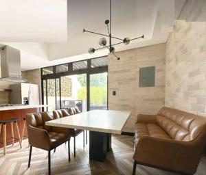 a dining room with a table and leather chairs at Venecia 1BR Zona 10 Luxury Suite - Pool, Jacuzzi, Gym & View in Guatemala