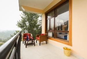 a balcony with two chairs and a table at Hotel Grand Nest in Dharamshala