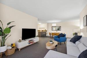 - un salon avec un canapé blanc et une télévision dans l'établissement Spacious Holiday Apart on Hay St CBD, à Perth