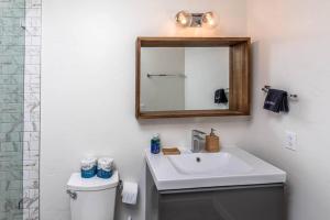 uma casa de banho com um lavatório branco e um espelho. em Pool Spa Fire Pit Pets Ensuite Bathrooms em Lake Havasu City