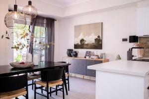 a kitchen and dining room with a black table and chairs at Stunning Northbridge Townhouse W Off St Parking in Perth