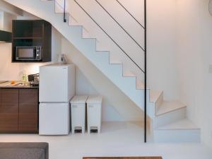 eine Küche mit weißen Geräten und eine Treppe in der Unterkunft 2023 Open Shinjuku Okubo 5mins to 2stns 200M WIFI in Tokio