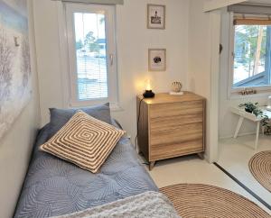 ein Schlafzimmer mit einem Bett, einer Kommode und einem Fenster in der Unterkunft SkyVillas Apartments by Hiekka Booking in Kalajoki