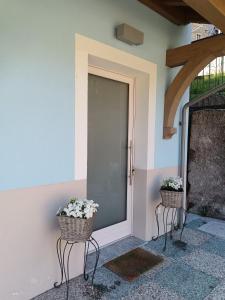 due cesti di fiori seduti sul lato di una porta di Idroblu Bondone Lago d'Idro a Bondone