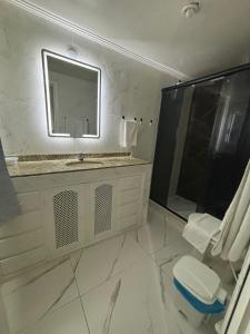 a white bathroom with a sink and a mirror at Pousada Oceanic in Arraial do Cabo