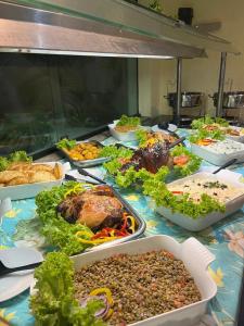 a table with many different dishes of food on it at Pousada Oceanic in Arraial do Cabo