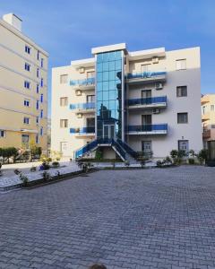 un gran edificio de apartamentos con una calle adoquinada en Ilirian Hotel, en Lezhë