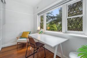 Elegant 1-Bed CBD Apartment with Sunroom Study في ملبورن: طاولة بيضاء وكراسي في غرفة مع نافذة