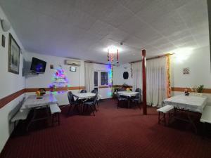 a dining room with tables and a christmas tree at Vila Șoimul Predeal in Predeal