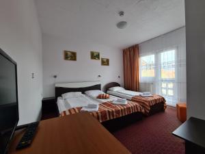 a hotel room with two beds and a desk at Vila Șoimul Predeal in Predeal