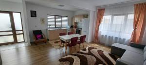 ein Wohnzimmer mit einem Tisch und einer Küche in der Unterkunft Apartament Sânpetru-Brașov in Sînpetru