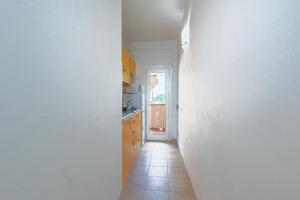 un couloir avec un mur blanc et une cuisine dans l'établissement Monte Majore House 70B - Happy Rentals, à Porto Rotondo