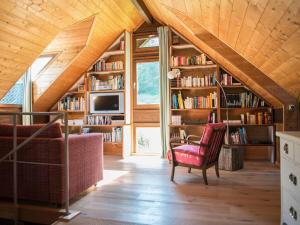 ein Zimmer mit Bücherregalen und einem Stuhl in einem Haus in der Unterkunft Bergwiesen - Studio House 