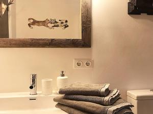 ein Badezimmer mit einem Hundebild an der Wand über einem Waschbecken in der Unterkunft Bergwiesen - Studio House 