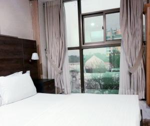 a bedroom with a bed and a large window at Islamabad Premium Hotel in Islamabad