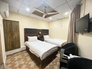 a hotel room with two beds and a tv at Islamabad Premium Hotel in Islamabad