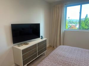 1 dormitorio con TV en un tocador con cama en New and Bright Bedroom Ensuite, en Los Ángeles