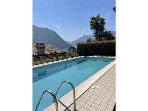 a swimming pool with mountains in the background at Acqua Dolce Comfortable holiday residence in Sala Comacina