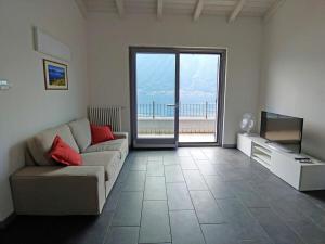 a living room with a couch and a television at Acqua Dolce Comfortable holiday residence in Sala Comacina