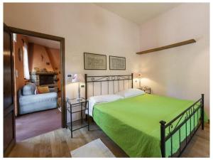 1 dormitorio con 1 cama con manta verde en Villa Montecchio, en Cortona