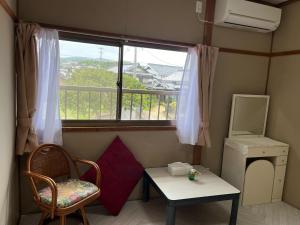 a room with a window and a table and a chair at ばんぶ〜ハウス(BambooHouse) in Shimo-ōzu