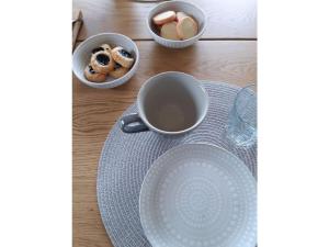 a table with a cup of tea and bowls of food at House Sjötorp Comfortable holiday residence in Hjältevad
