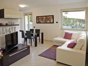 ein Wohnzimmer mit einem weißen Sofa und einem Tisch in der Unterkunft le Camelie Comfortable holiday residence in Menaggio