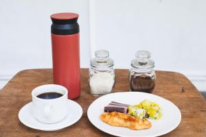 a table with a plate of food and a cup of coffee at Camani Glamping in Karangasem