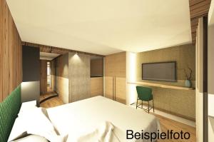 ein Schlafzimmer mit einem Bett und einem TV an der Wand in der Unterkunft Obergrundhof in Leogang