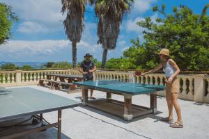 伊埃爾的住宿－Camping International & Spa 4*，一名妇女在乒乓球桌上打乒乓球