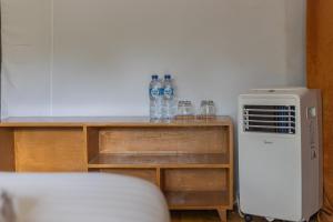 ein Zimmer mit Kühlschrank und Wasserflaschen in der Unterkunft Camani Glamping in Karangasem
