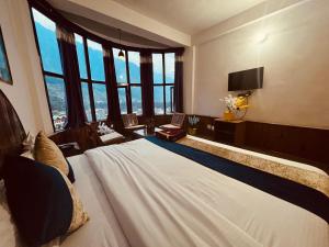 a bedroom with a large bed with large windows at Gangari Home stay in Bharūch