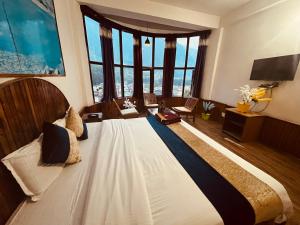a large bed in a room with large windows at Gangari Home stay in Bharūch