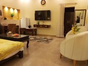 a living room with a couch and a tv at Hotel Luxe Heights Lahore in Lahore