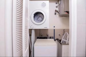 eine Küche mit einer Waschmaschine und einer Waschmaschine in der Unterkunft Exceptional Apt in the heart of Perth City in Perth
