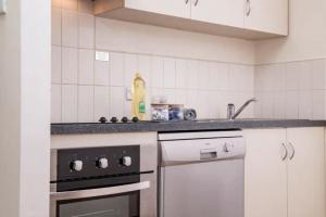 a kitchen with a stove and a sink at Exceptional Apt in the heart of Perth City in Perth