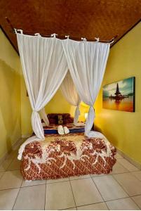 a bedroom with a bed with a canopy at Villa Selina in Tejakula